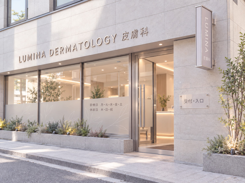 金属切り文字、縦型突き出し看板、入口プレート、すりガラス調ウィンドウサインを組み合わせた皮膚科クリニックのデザインイメージ