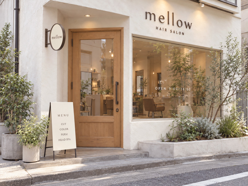 木目と白を基調に、切り文字・丸型突き出し看板・スタンド看板・ウィンドウサインを組み合わせた美容室のデザインイメージ